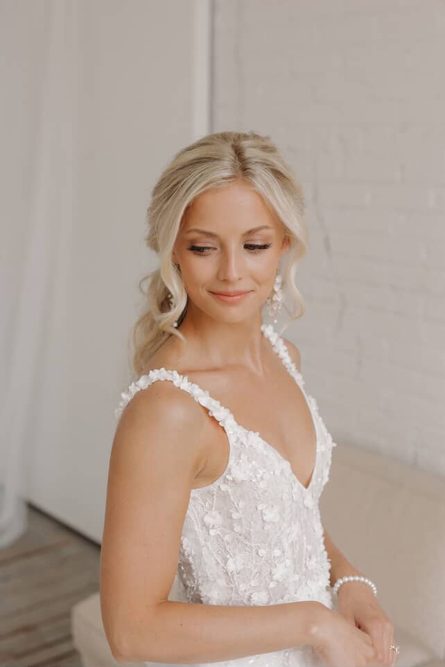 A bride with soft glam makeup and elegant styled hair by Captivating Beauty