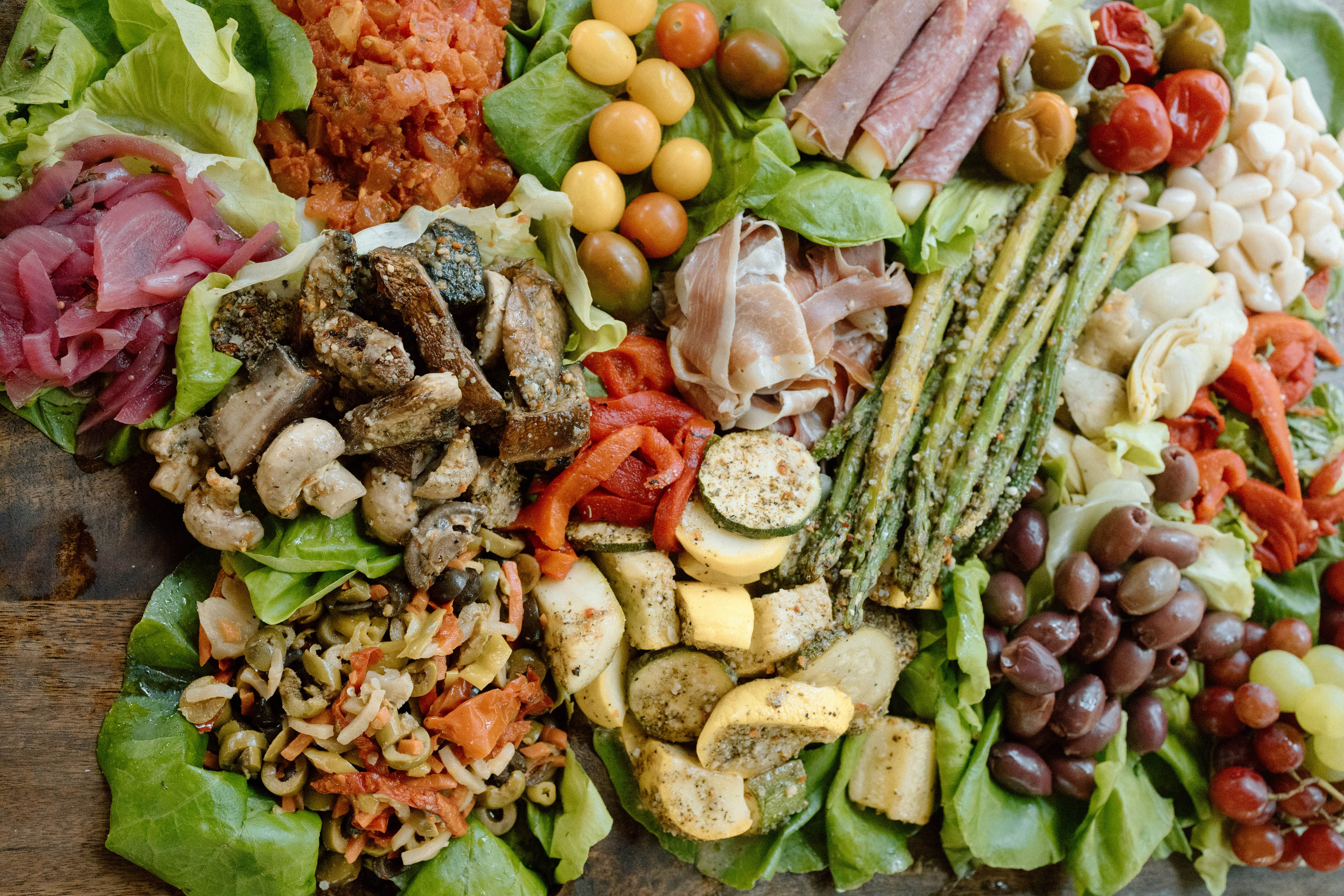 A colorful seasonal shared meal arranged with roasted vegetables, greens, and fresh produce