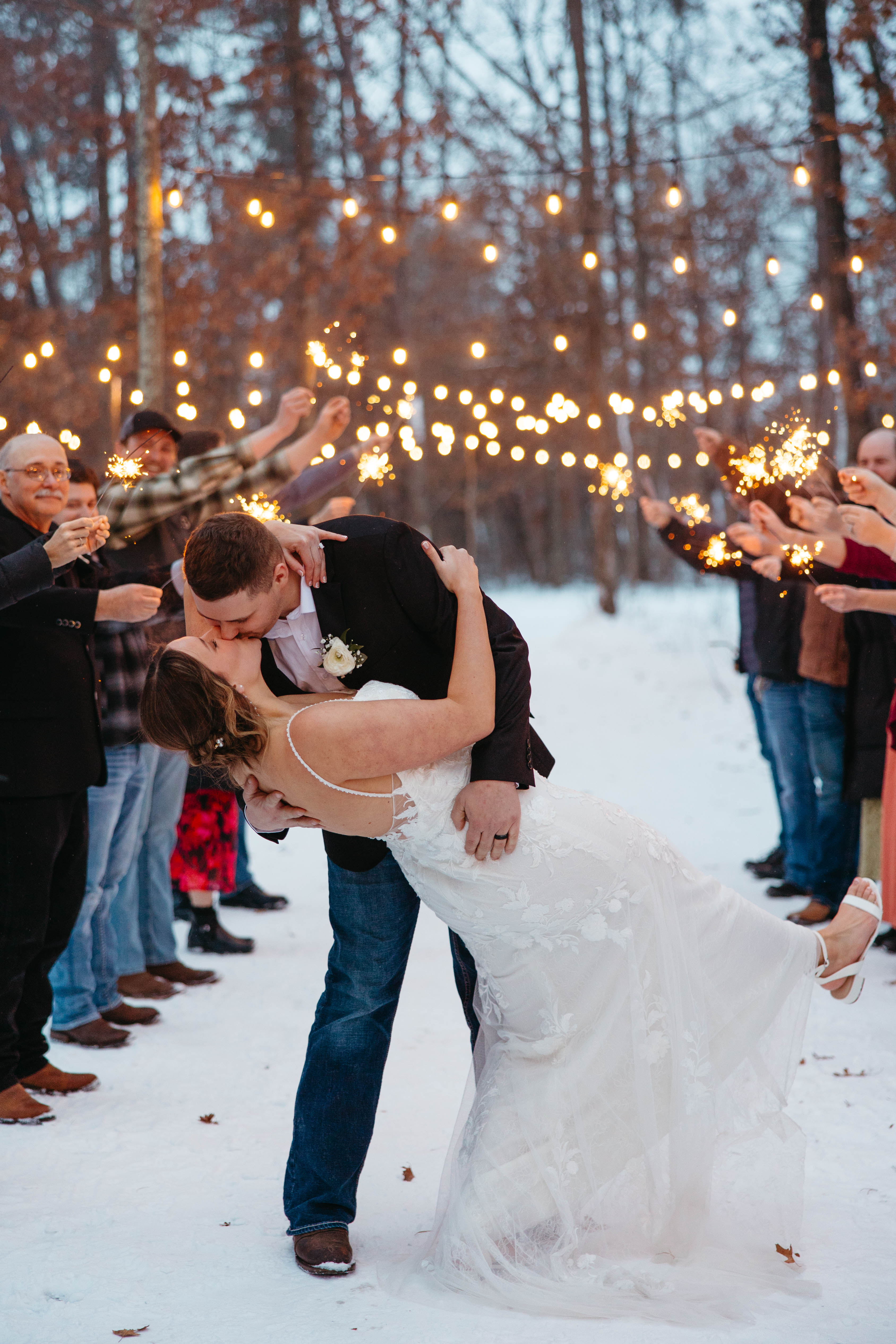 Guests holding sparklers during a joyful winter wedding send-off